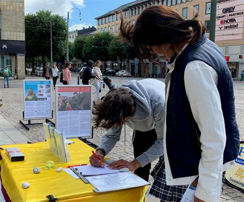 '图3:瑞典年轻人签名反对中共活摘法轮功学员器官'