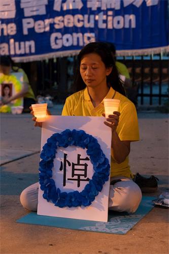 '图6~8:法轮功学员在芝加哥中领馆前举行烛光夜悼,悼念被中共迫害致死的同修。'