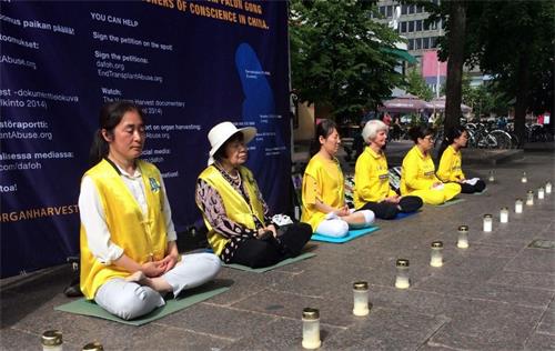 '图2:法轮功学员在甘比购物中心前烛光守夜。'