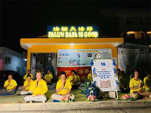 '图:部份塞班岛的法轮功学员们在法轮大法佛学会门前举办悼念活动'
