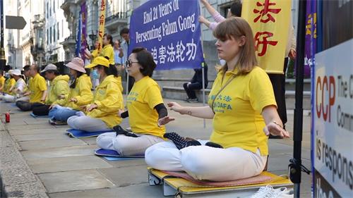 '图6:二零二零年七月二十日, 英国法轮功学员尤丽雅(Yulia,右)参加在伦敦中共使馆前的集体炼功'