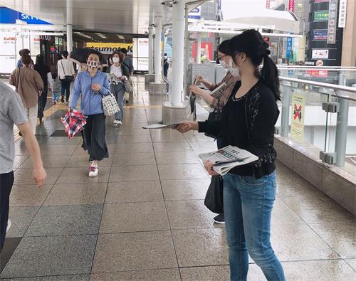 '图3:法轮功学员在柏车站派发法轮功真相资料'