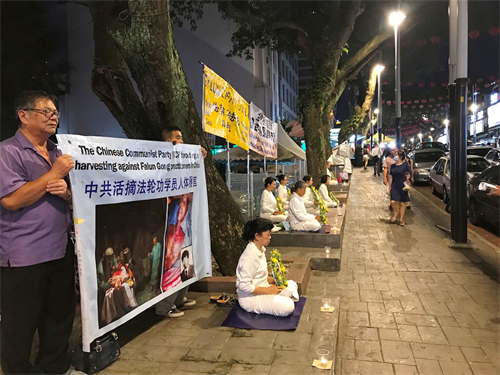 '图5~6:七月十九日晚上,部份法轮功学员在吉隆坡亚罗街(Jalan Alor),悼念被中共迫害的法轮功学员。'