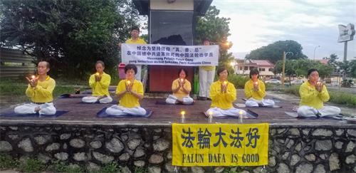 '图10:七月十八日早上,柔佛州新山彩虹花园(Taman Pelangi)的部份法轮功学员在炼功点举行悼念活动,希望更多的民众能了解真相。'