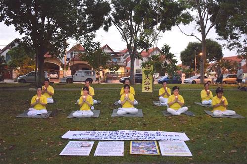 '图11:七月十九日早上,柔佛州新山开屏花园(Taman Pelangi Indah)的部份法轮功学员在炼功点举行悼念活动,希望更多的民众能了解真相。'