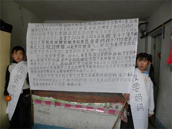 '贾彬的孩子身披“我要妈妈,我要吃饭”的条幅'