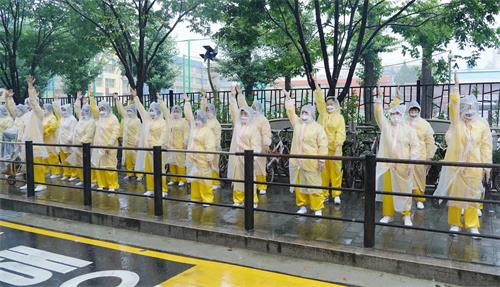 '图13:声援3.6亿中国人三退大游行接近终点时,法轮功学员在街边展示功法。'