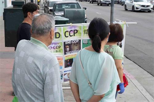 '图10:唐人街的顾客在观看真相图片展'