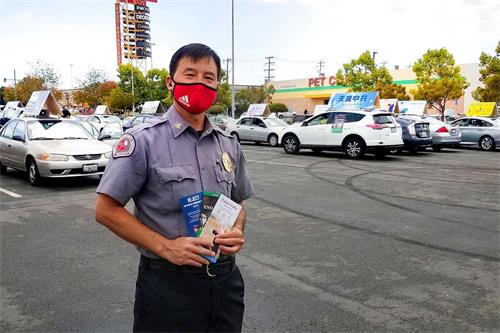 '图13:购物中心的保安飞利浦高兴地拿着真相资料'