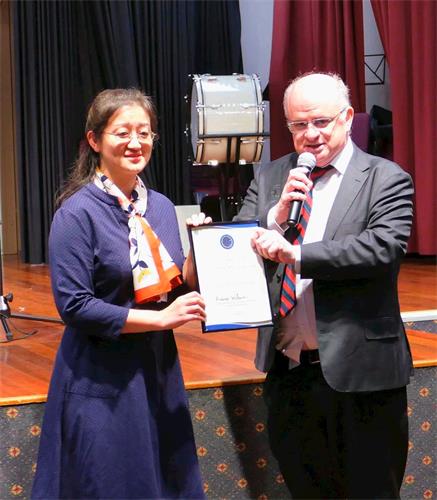 '图4:二零一九年五月三日,悉尼帕拉马塔市(City of Parramatta)市长威尔逊(右)向澳洲法轮大法学会会长赵博士(Dr Lucy Zhao)颁发了褒奖令,表彰法轮大法为当地社区所作出的贡献,并祝贺法轮大法弘传世界27周年。'