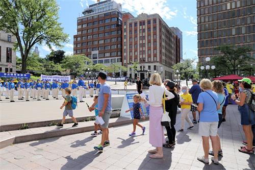 '图1~3:2020年8月22日,加拿大魁北克省部份法轮功学员在省府魁北克市中心的杜维尔(D'Youville)广场举行集会活动,呼吁结束中共对法轮功长达21年的迫害。'