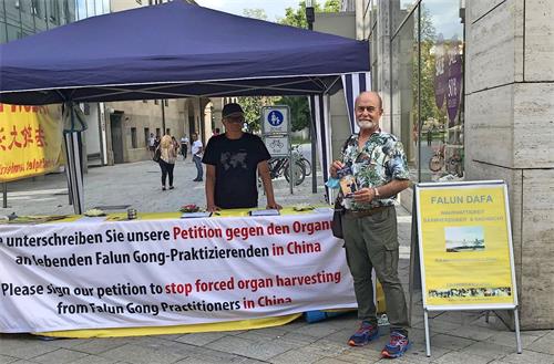 '图4:金教授在“请签名制止活摘法轮功学员器官”的横幅前留影'