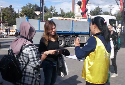 '图2:学员在跟市民讲述法轮功真相。'