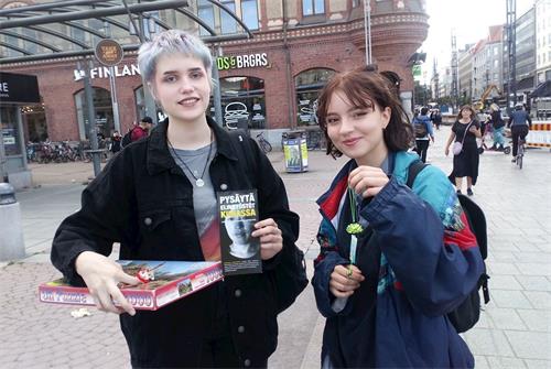 '图6:市民高兴的举起法轮功学员赠送的莲花。'