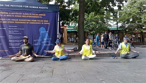 '图1:法轮功学员在购物中心甘比外举办讲真相活动,揭露中共对法轮功长达二十一年的残酷迫害。'