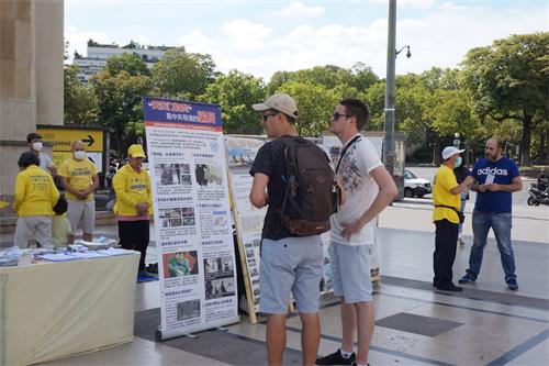 '图5~8:游人在驻足观看真相展板,并和学员交谈'