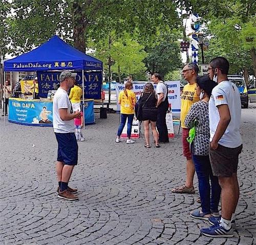 '图2～3：法轮功学员跟民众讲述二十一年来反迫害的真相。'