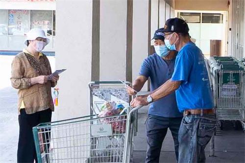 '图12:法轮功学员向华人超市顾客派发资料'