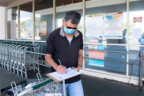 '图14:胡先生在铲除中共邪灵的征签表上签字'