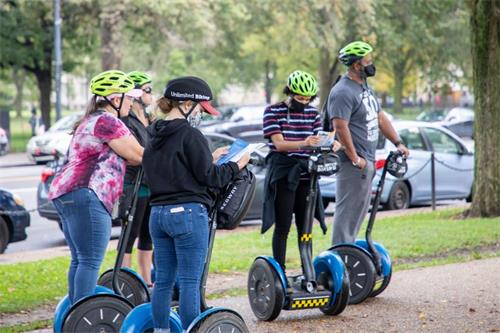 '图5~6:游客从法轮功学员手中接过真相材料。'