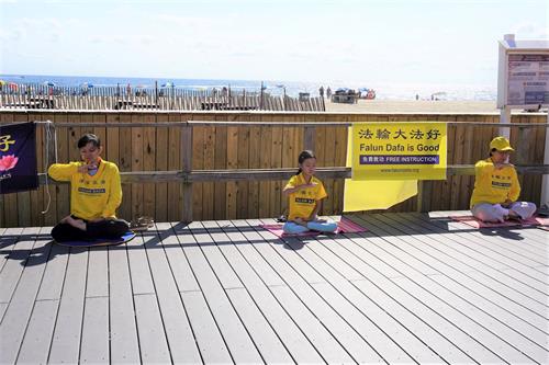 '图1~4:法轮功学员在海滨木板路上的功法展示'