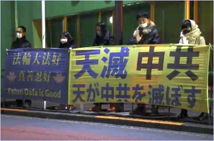'图:在寒夜里,法轮功学员手持“法轮大法好、真善忍好” ,“天灭中共”的横幅,呼吁解体中共,停止迫害。'