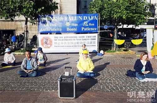 '图1~2:二零二一年十月九日,巴黎法轮功学员在市中心的地铁站夏特蕾(Chatelet Les Halles)门前广场,举办了真相日活动。图为法轮功学员在展示五套功法。'
