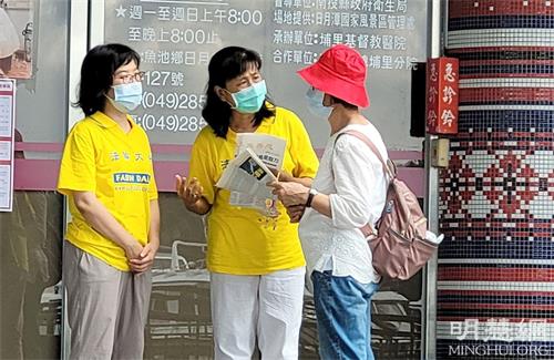 '图2:明白真相的有缘人(戴红色帽子),来到淑贞面前双手合十,表示感谢,对法轮功学员坚持讲真相的精神与毅力感到佩服。'