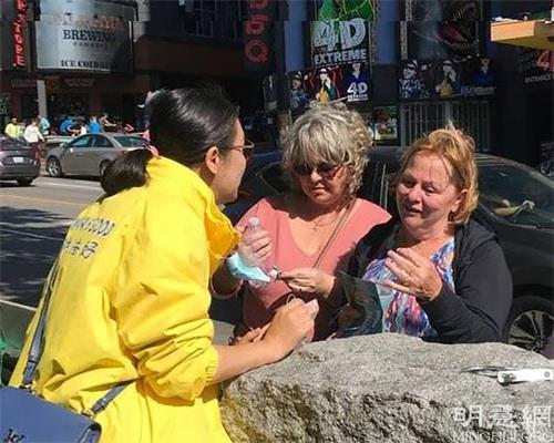 '图12:西人女士朱迪Judy(右一)在询问炼功信息。学完功后感叹功法的神奇。'