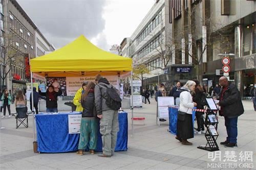 '图1:二零二一年十月十六日,法轮功学员在德国汉诺威(Hannover)中心火车站附近的步行街举办了信息日活动,向当地居民介绍法轮功的真相。'