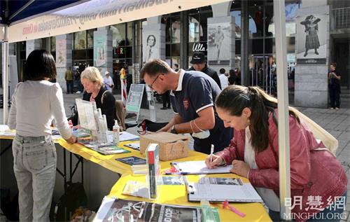 '图4:十月二日,在康士坦茨(Konstanz)的奥古斯缇纳(Augustinerplatz)广场上,了解真相后的路人签名支持制止中共活摘罪行。'