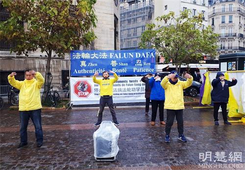 '图4:二零二一年十一月十三日,在夏特蕾地铁站外,法轮功学员展示法轮功功法。'