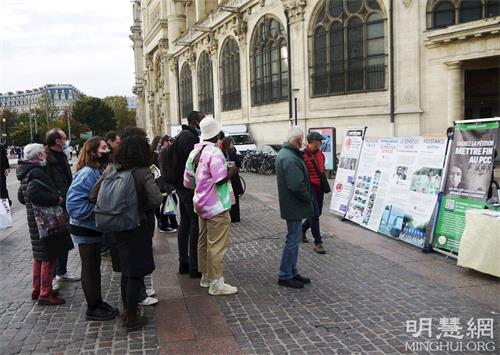 '图7:二零二一年十一月六日,在夏特蕾地铁站外,人们观看法轮功展板,了解真相。'