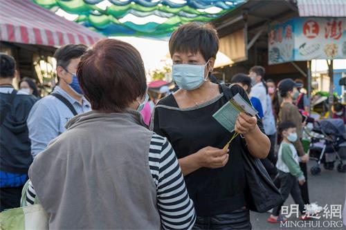 '图4:一位女士想学炼,向法轮功学员询问修炼方法和炼功点资讯。'