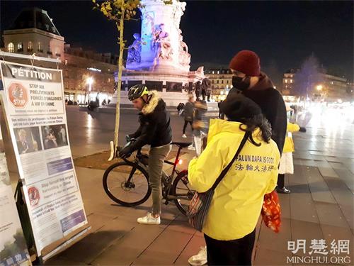 '图2:二零二一年十二月十日,国际人权日当天,在巴黎共和国广场,人们专注看展板,了解法轮功真相。'