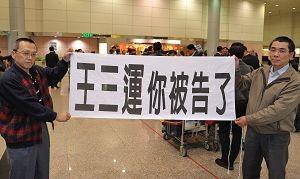 “你被告了”--中共人权恶棍安徽省长王三运访台,法轮功学员在机场中拉横幅