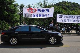 “你被刑事控告了”——安徽省省长王三运四月二十日上午至桃园县桃园铭传大学时,车队在校园路前看到法轮功学员的抗议横幅