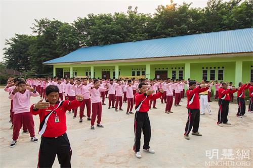 '图7~8:阿尔加利亚职业高中(SEKOLAH MENENGAH KEJURUAN ALJABAR)老师和学生和巴丹岛法轮功学员一同炼功。'