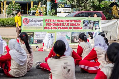 '图12:二零一六年十一月十一日,巴丹岛法轮功学员第二次到Kolese Tiara Bangsa 高职教学生炼法轮功功法。教功后,法轮功学员向Tiara Bangsa 高职学生讲述中共活摘法轮功学员器官的罪行。'