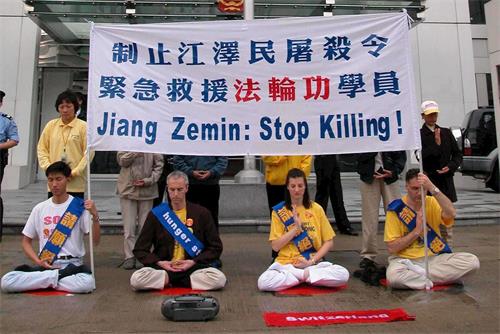 '图2:二零零二年三月十四日,包括四名瑞士人在内的十六名法轮功学员在香港中联办大楼外的街边进行和平请愿。'
