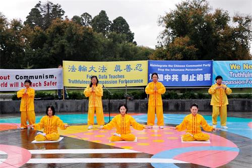 '图1:二零二一年四月十日,法轮功学员在澳洲第四大城市本迪戈市中心举办汽车游行和集会。图为在集会上,法轮功学员展示五套功法。'