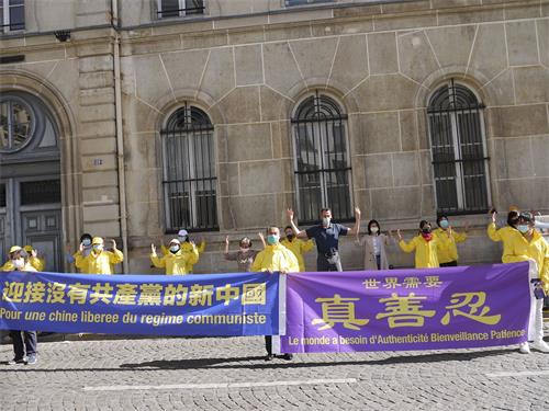 '图1~2:法轮功学员在巴黎中使馆前举行集会,告诉人们法轮功真相,揭露中共二十多年来对法轮功的残酷迫害。'
