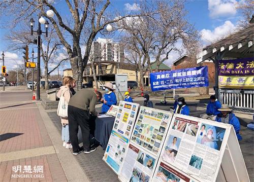 '图1~2:二零二一年四月二十四日,加拿大埃德蒙顿部份法轮大法学员在威尔伯特·麦金太尔博士公园传播真相,纪念四·二五和平上访二十二周年。了解真相后的市民签名反对中共迫害法轮功。'