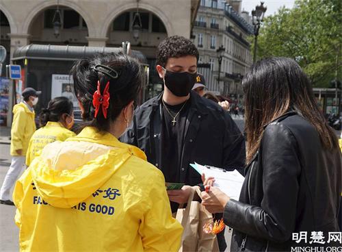 '图11:爱德华多(中)在反迫害征签表上签名'