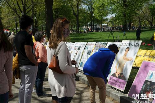 '图6:路人驻足观看真相展板'