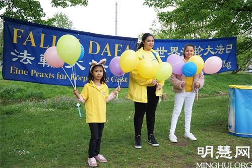 '图3:大法小弟子萨拉(Sara K.,中)和其他孩子一起参加了2021年5月13日在纽伦堡沃德湖畔的法轮大法日庆祝活动。'