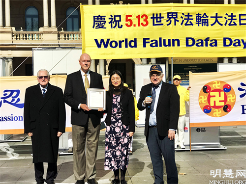 图4:帕拉马塔市议员威尔逊(Andrew Wilson)(右一)在集会上代表市长鲍勃·德威尔(Bob Dwyer)向法轮功团体颁发褒奖令