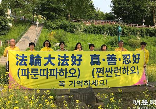 图4:为庆祝法轮大法日,首尔部分学员在瑞草区良才川集体炼功后,恭祝师尊生日快乐!