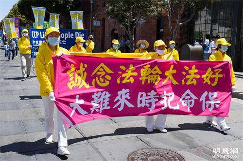 '图5~21:旧金山法轮功学员在渔人码头旅游景点游行,恭祝师父华诞,庆祝“世界法轮大法日”。'