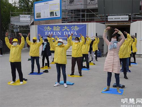 '图1:五月二十三日,法轮功学员在红山圣皮埃尔( Saint-Pierre de Montrouge)教堂前向行人展示法轮功功法,介绍法轮功。'